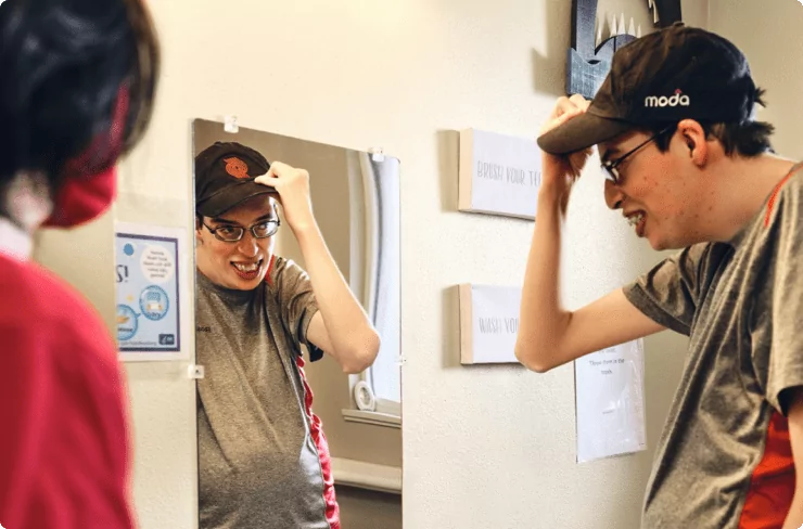 young-adult-with-intellectual-or-developmental-disabilities-gets-ready-for-work-and-poses-in-front-of-mirror