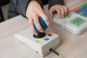 Closeup of person using joy stick computer assistive technology. 