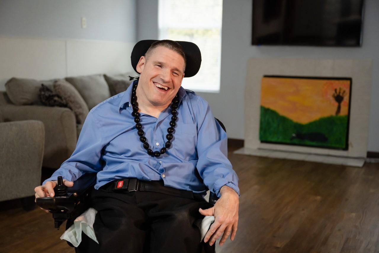 A developmentally disabled individual sitting in a wheelchair in his home.