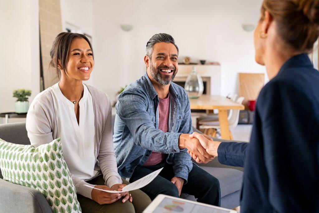 a multi-racial couple meets with a financial planner to discuss future financial needs. 