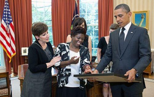 President Barack Obama receives a painting from African American artist and disabled advocate Lois Curtis.