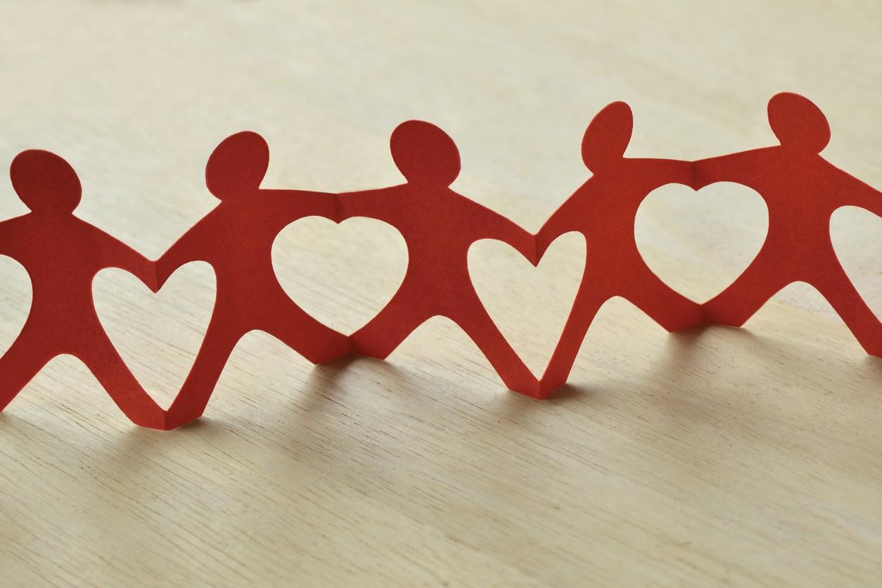 A string of red paper doll cutouts signifying working together to make an impact.
