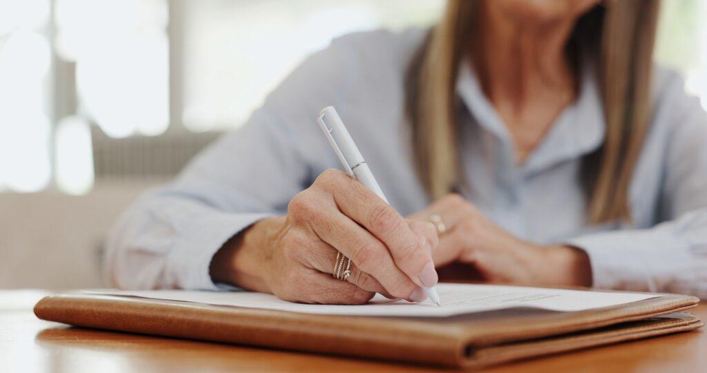 Close up of a woman writing a letter as a volunteer advocating for disability rights.