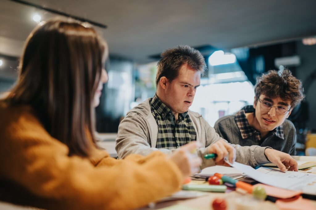 Three developmentally disabled students work on a class high school project.
